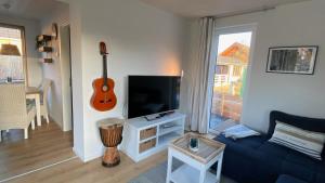 a living room with a blue couch and a guitar at Tiny House mit Sauna am See in Repente