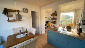 a kitchen with blue cabinets and a wooden table at Tiny House mit Sauna am See in Repente