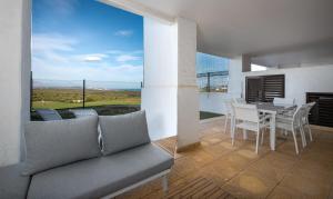 salon z kanapą, stołem i krzesłami w obiekcie Alcaidesa Golf and Beach 2356 w mieście La Alcaidesa