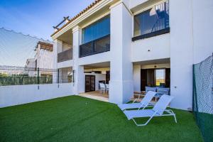 dom z trawnikiem z krzesłami w obiekcie Alcaidesa Golf and Beach 2356 w mieście La Alcaidesa
