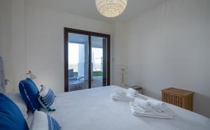 biała sypialnia z łóżkiem i ręcznikami w obiekcie Alcaidesa Golf and Beach 2356 w mieście La Alcaidesa