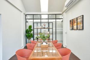 a conference room with a wooden table and pink chairs at Be Phrasingh Hotel Chiang Mai in Chiang Mai +38 photos