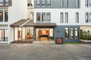 a house with aconservatory in front of a building at Be Phrasingh Hotel Chiang Mai in Chiang Mai