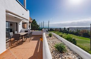 eine Terrasse mit einem Tisch und Stühlen auf einem Haus in der Unterkunft Lotus 2401 - Beautiful apartment with pool & sea view in Casares