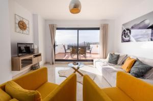 salon z 2 kanapami i stołem w obiekcie Lotus 2401 - Beautiful apartment with pool & sea view w mieście Casares