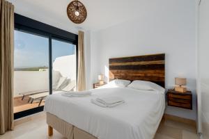 sypialnia z dużym łóżkiem i dużym oknem w obiekcie Lotus 2401 - Beautiful apartment with pool & sea view w mieście Casares +24 zdjęcia