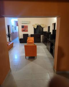 uma sala de estar com uma cadeira laranja e um sofá em Eko Akete Guest House em Abeokuta