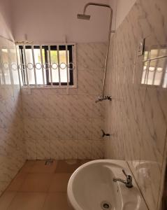 a bathroom with a tub and a sink and a window at Eko Akete Guest House in Abeokuta