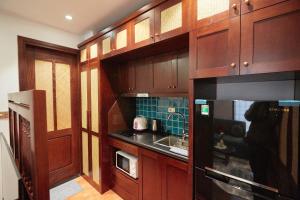 a kitchen with wooden cabinets and a sink and a microwave at Camellia Residence Hanoi in Hanoi