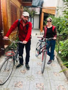Un hombre y una mujer de pie con sus bicicletas. en Tam Coc The Moon Lady Homestay, en Ninh Binh