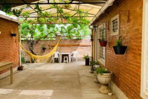 un patio con hamaca y pared de ladrillo en Casa de Huéspedes en Playas de Oro. en Villa Carlos Paz