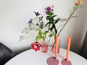 zwei Vasen mit Blumen auf dem Tisch in der Unterkunft Haus Deckerstraße-Goebel in Westerland