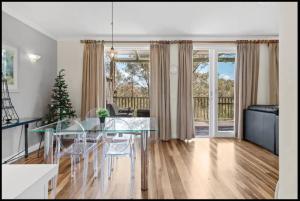 een eetkamer en een woonkamer met een glazen tafel bij King Villa Retreat / Hunter Valley in Pokolbin