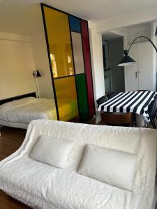een woonkamer met 2 bedden en een witte bank bij Numéro 5 in Boulogne-Billancourt