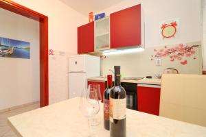 eine Flasche Wein und zwei Gläser auf der Küchentheke in der Unterkunft Seafront Apartments Anthony in Lastovo
