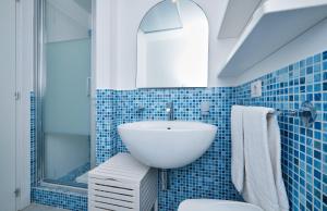 een blauw betegelde badkamer met een wastafel en een toilet bij Case Vacanze Pomelia in Marina di Ragusa