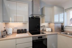 a kitchen with white cabinets and a counter top at 61 Deneside in Lanchester