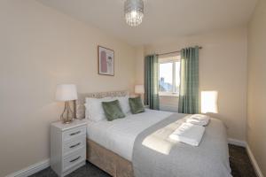 a bedroom with a white bed with a window at 61 Deneside in Lanchester