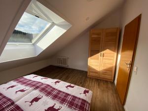 een slaapkamer op zolder met een bed en een raam bij Schwarzwaldnest in Todtmoos