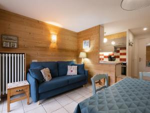 拉克呂薩的住宿－Appartement La Clusaz, 2 pièces, 6 personnes - FR-1-304-98，一间带蓝色沙发的客厅和一间厨房