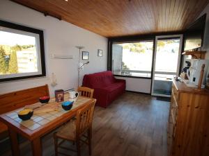 シャンルッスにあるAppartement Chamrousse, 2 pièces, 4 personnes - FR-1-340-81のリビングルーム(テーブル、赤いソファ付)