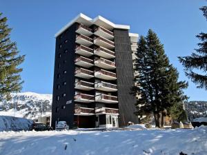 een hoog gebouw met sneeuw ervoor bij Appartement Chamrousse, 2 pièces, 6 personnes - FR-1-340-101 in Chamrousse