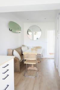 a white living room with a table and a mirror at The Palm House Falmouth - minutes from the beach! in Falmouth