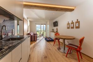 a kitchen with a table and a dining room at Almfrieden Hotel & Romantikchalet in Ramsau am Dachstein