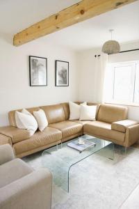 a living room with a couch and a glass table at The Palm House Falmouth - minutes from the beach! in Falmouth