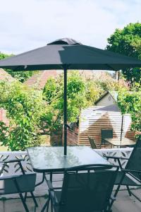 a table and chairs with an umbrella on a patio at The Palm House Falmouth - minutes from the beach! in Falmouth
