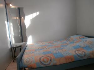 a bedroom with a bed with an orange and blue comforter at Appartement Seignosse, 2 pièces, 4 personnes - FR-1-239-460 in Seignosse