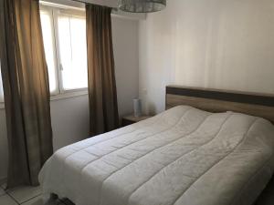 a bedroom with a white bed with a window at T2 Rénové avec Terrasse à 200m de la Plage, Proche Commerces - Les Sables-d'Olonne - FR-1-92-814 in Les Sables-dʼOlonne