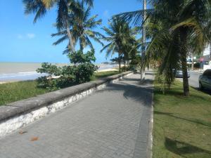 una acera de ladrillo junto a una playa con palmeras en Terrazzas Flat 106, en João Pessoa