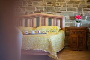 a bedroom with a bed and a stone wall at Bayview Studio in Kritharia