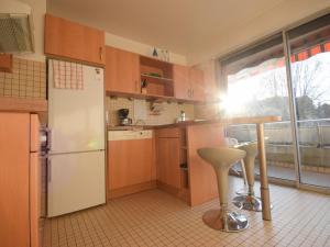 a kitchen with a white refrigerator and a counter with a stool at Appartement charmant avec parking à Évian - FR-1-498-13 in Évian-les-Bains