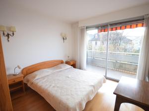 a bedroom with a bed and a large window at Appartement charmant avec parking à Évian - FR-1-498-13 in Évian-les-Bains