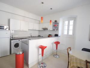 uma cozinha com armários brancos e bancos vermelhos em Appartement Évian-les-Bains, 2 pièces, 4 personnes - FR-1-498-14 em Évian-les-Bains