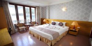 a hotel room with a large bed and a balcony at MayHouse Travel in Hanoi