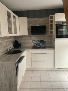 a kitchen with white cabinets and a sink at Ferienwohnung Zweite Heimat 45248 in Ditzum