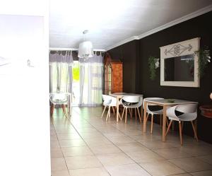 un comedor con mesa y sillas y una habitación con ventana en Kroon Manor, en Kroonstad