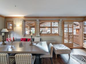 a dining room with a table and chairs and windows at Chalet cosy au centre de Courchevel Le Praz avec sauna, terrasse et parking - FR-1-568-15 in Courchevel +5 photos