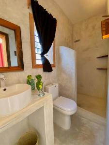 a bathroom with a sink and a toilet and a sink at Lala salama Kendwa villas in Kendwa