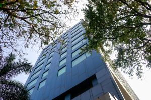浦那的住宿－浦那市中心萬豪萬怡酒店，一座高大的蓝色建筑,前面有树木