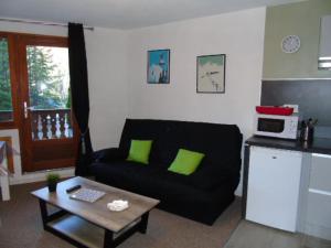ein Wohnzimmer mit einem schwarzen Sofa und einem Tisch in der Unterkunft Studio Modane, 1 pièce, 4 personnes - FR-1-561-100 in Modane