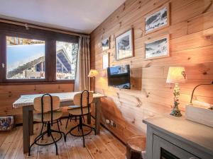 a room with a wooden wall with a table and chairs at Appartement confortable skis aux pieds avec parking couvert à Val-d'Isère - FR-1-694-58 in Val dʼIsère