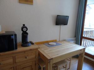 a room with a wooden table with a television and a wooden table sidx sidx sidx at Studio Valfréjus, 1 pièce, 3 personnes - FR-1-561-106 in Modane