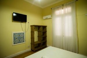 a bedroom with a bed and a television on the wall at Hosteria San Martin in San Salvador de Jujuy