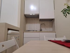 a white kitchen with a table and a sink at La Fenice in Agropoli
