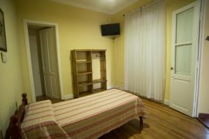 a bedroom with a bed with a striped blanket at Hosteria San Martin in San Salvador de Jujuy
