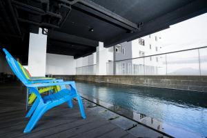 a blue chair sitting on a dock next to a river at M Living at Menara One in Solo